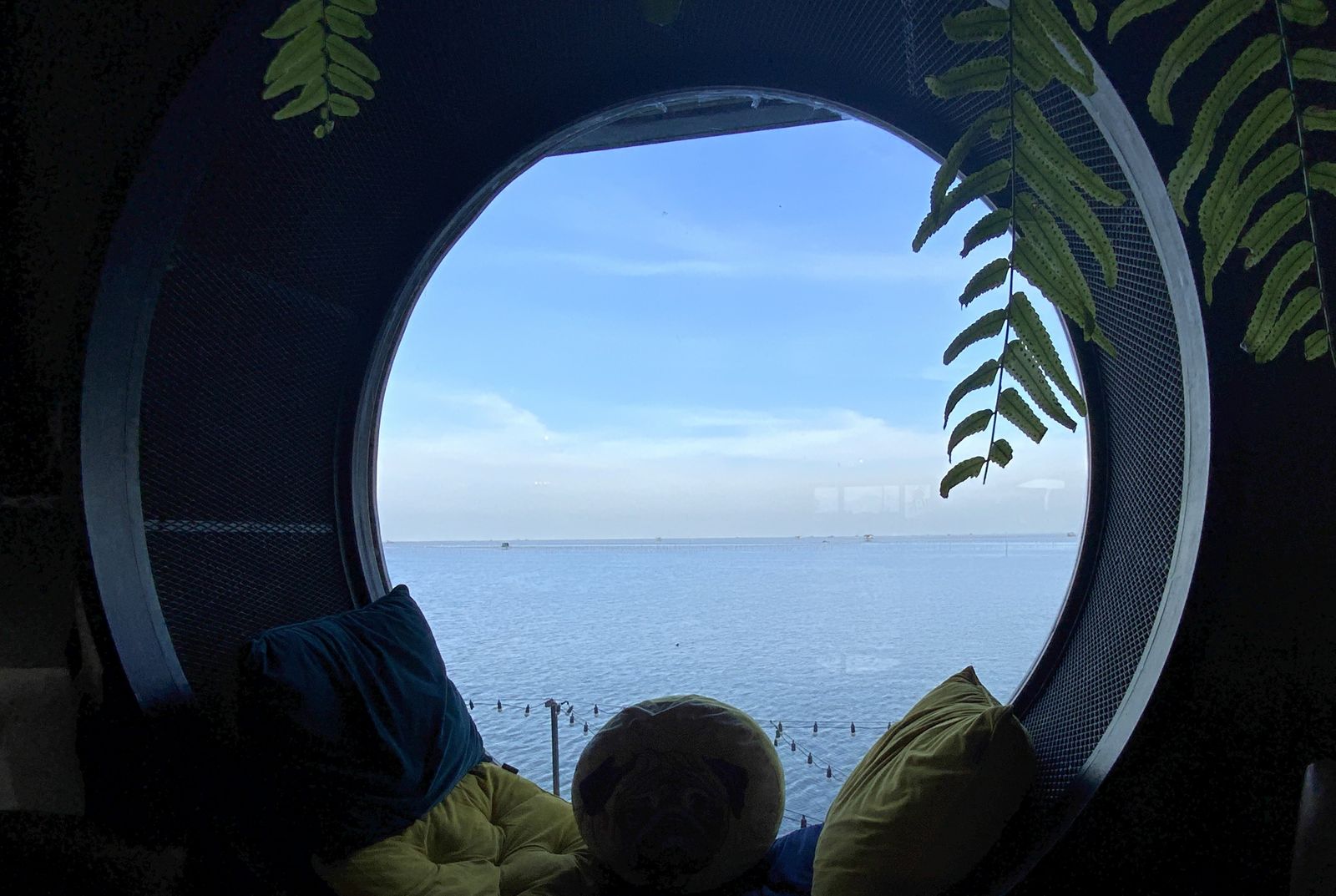 View through a round window at Cafe on Saphan out to a calm sea
